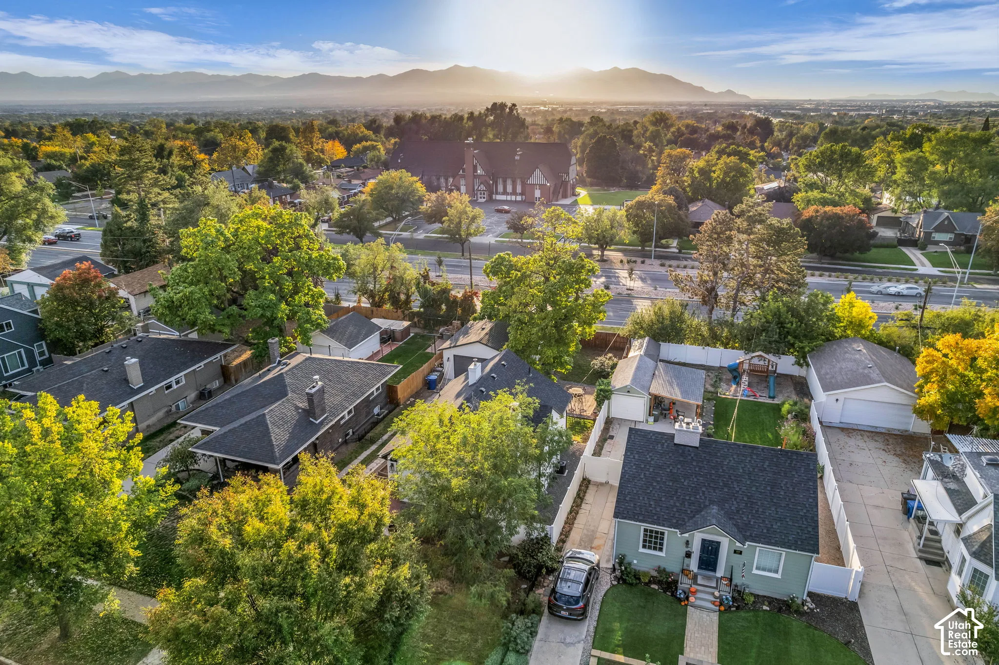 Mountain backdrop, lush trees, well-maintained lawn, paved driveways, and a single-story residence