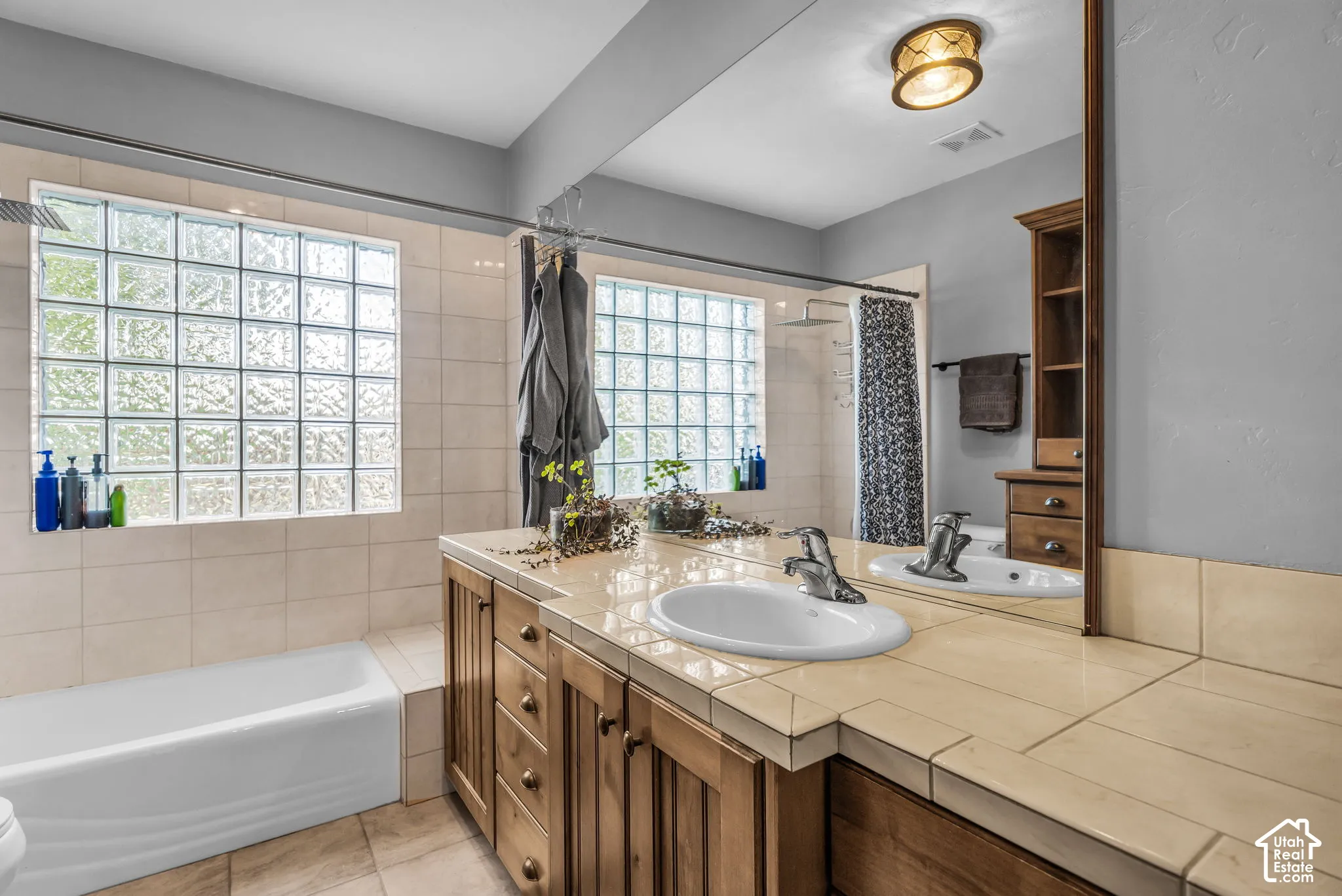 Wood-finish vanity with tile countertop and integrated sink