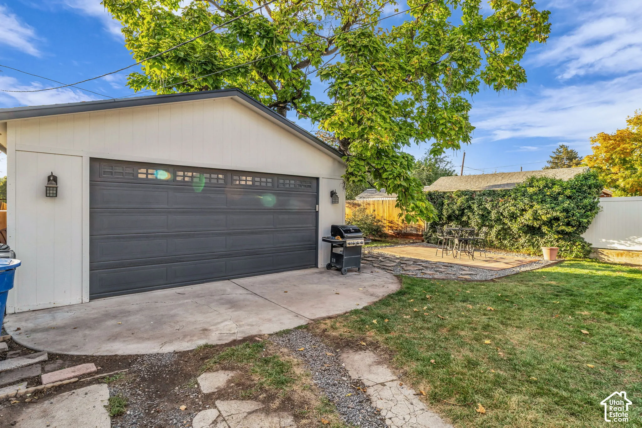 Exterior garage with a dark gray overhead door and decorative window inserts, complemented by a concrete driveway