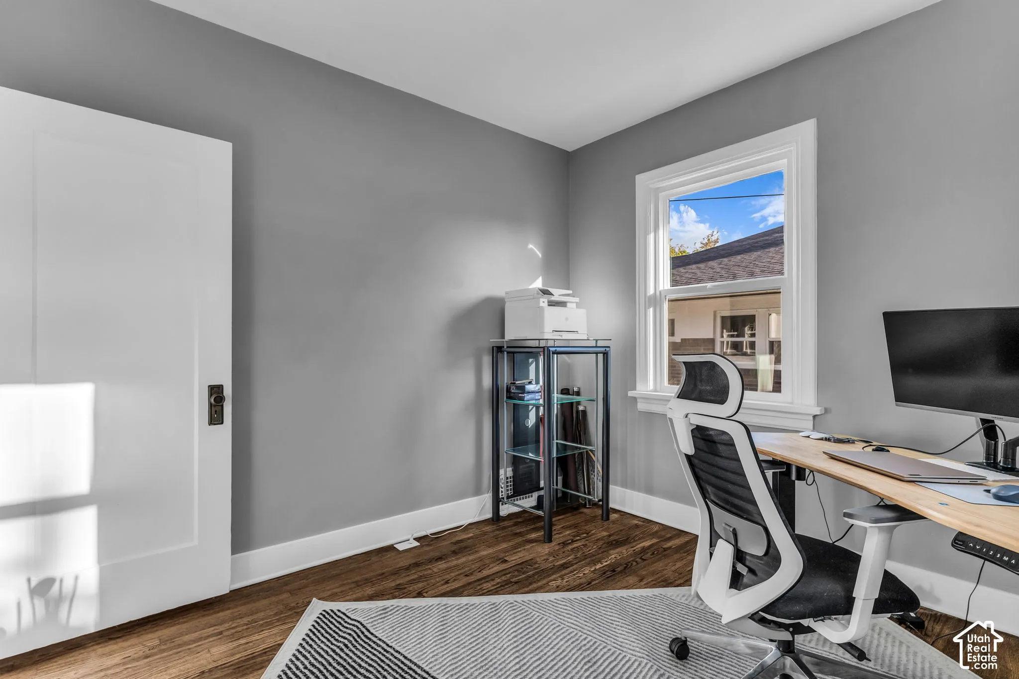 Refinished wood-finish flooring, crisp white trim, and a window with white casing