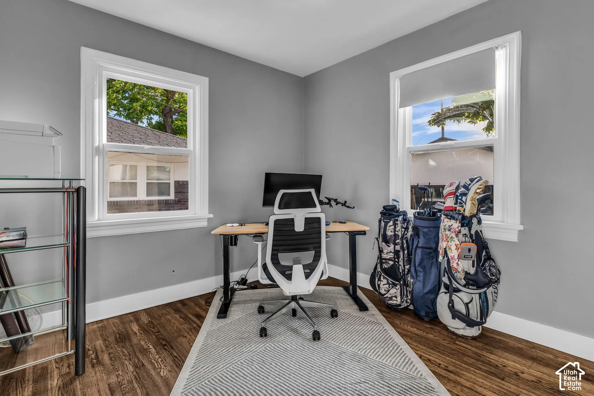 Hardwood-finish flooring, light grey wall paint, white window trim, and white baseboards