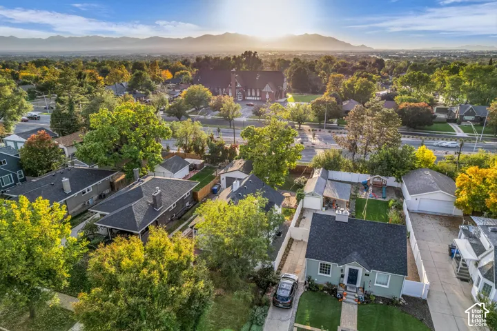 Mountain backdrop, lush trees, well-maintained lawn, paved driveways, and a single-story residence