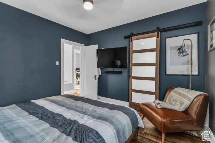 Wood-finish flooring throughout, complemented by a modern barn door with frosted panels
