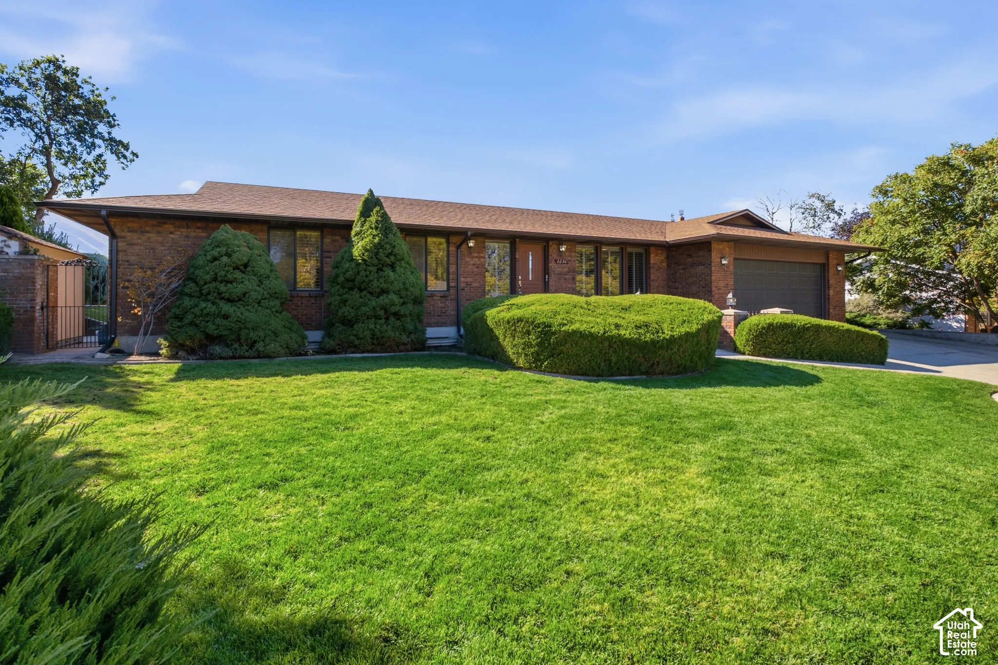 Brick exterior with a brown roof and integrated garage