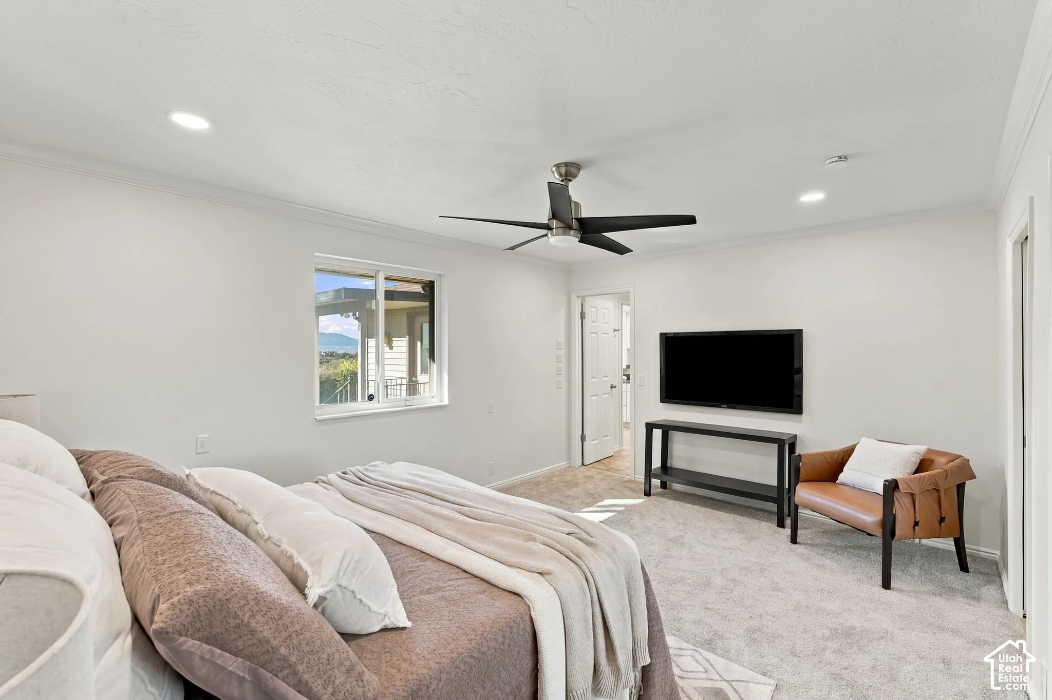 Recessed lighting, ceiling fan, white trim, wall-mounted television, and a window with outdoor scenery