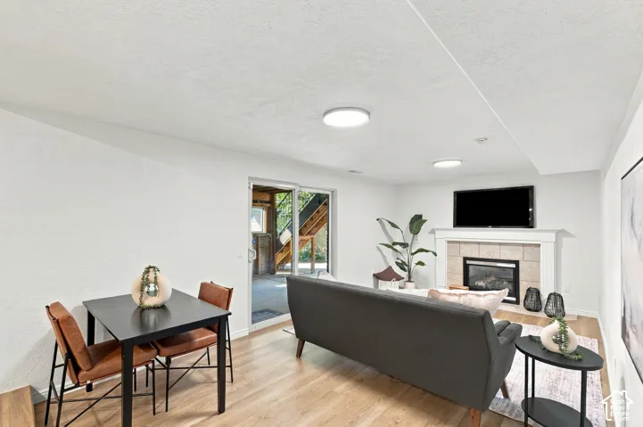Wood-finish flooring throughout, with a built-in fireplace featuring a tile surround and white mantel