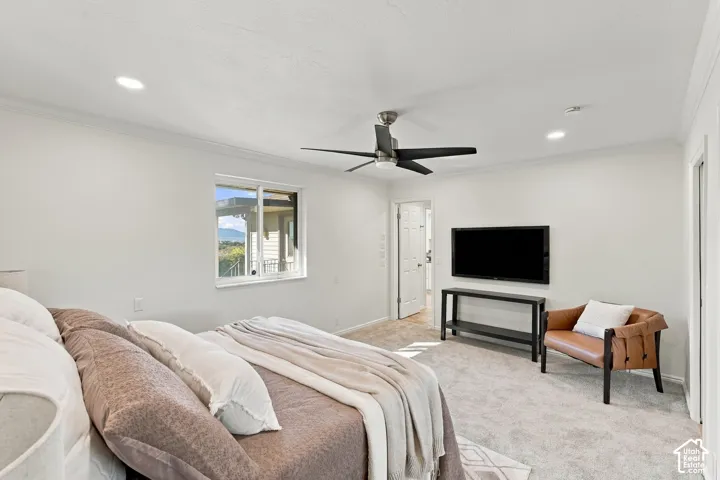 Recessed lighting, ceiling fan, white trim, wall-mounted television, and a window with outdoor scenery