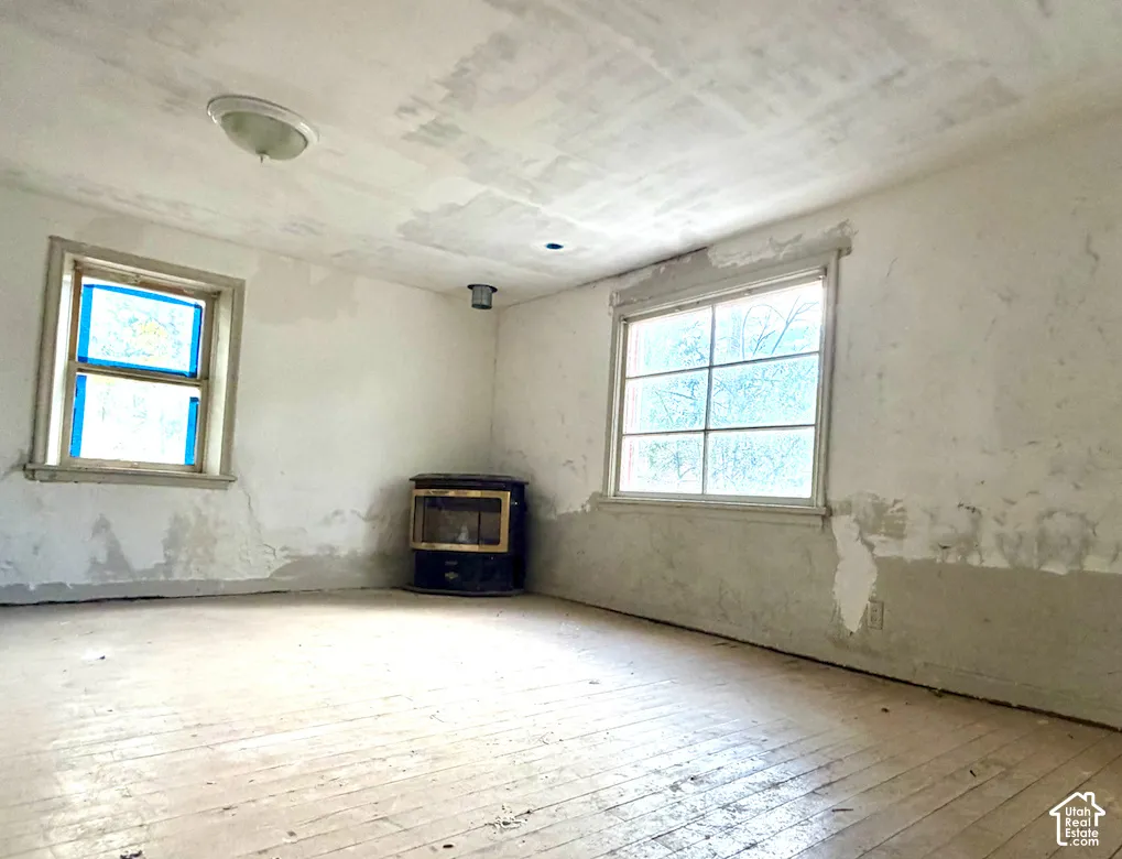 Wood flooring, multiple windows, and a built-in heating unit