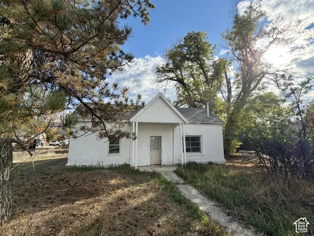 White stucco exterior with a covered porch and gabled entry
