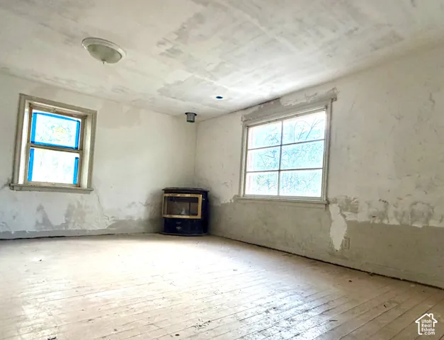 Wood flooring, multiple windows, and a built-in heating unit