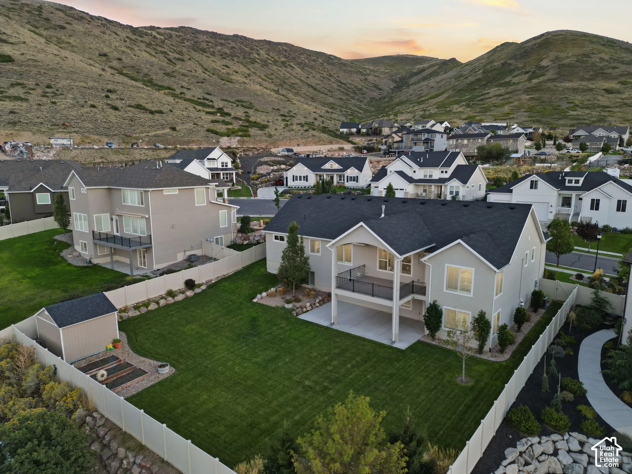 Contemporary residential architecture featuring a large, manicured lawn, an elevated deck, and a covered patio