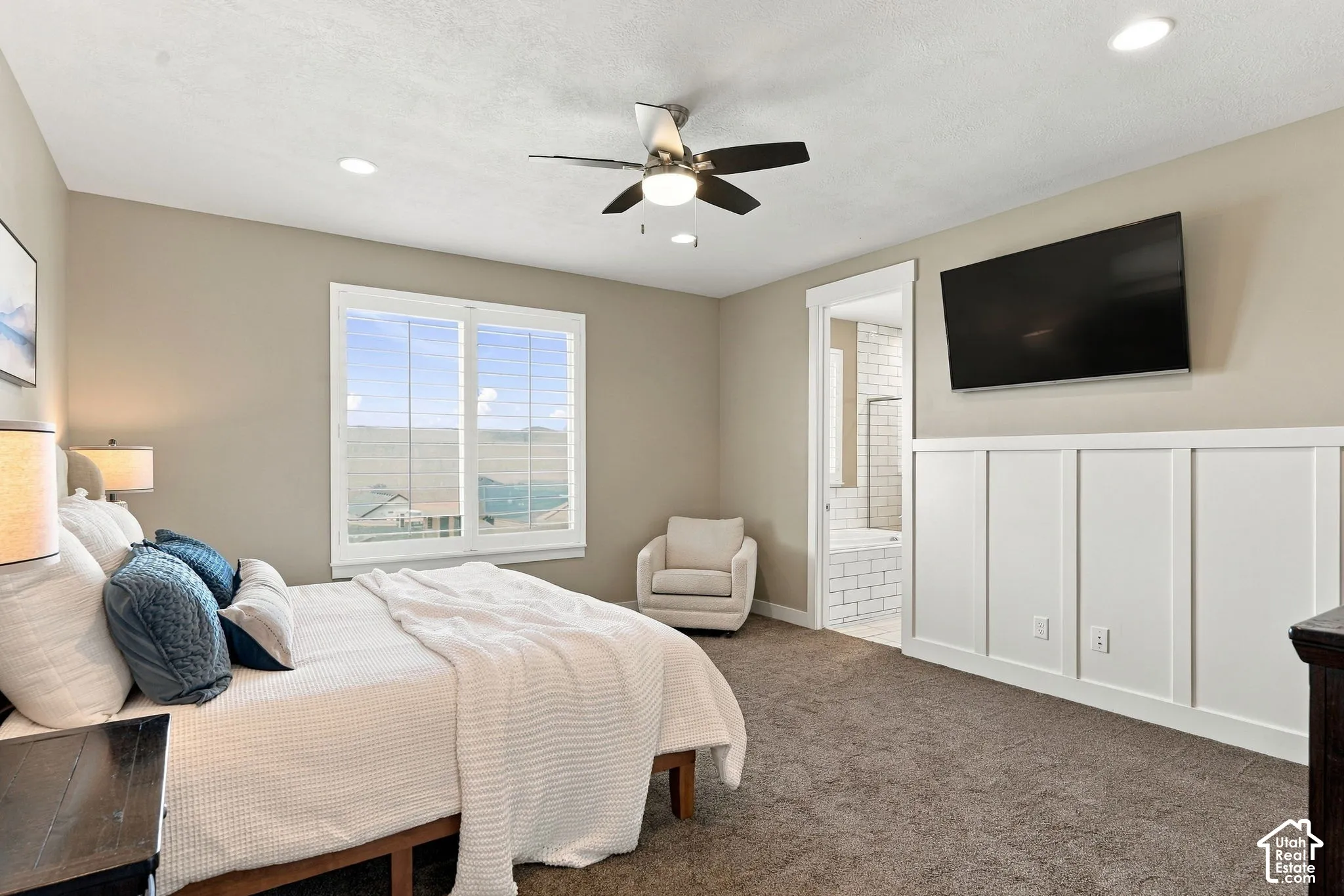 Recessed lighting, ceiling fan, white trim window, and board and batten accent wall