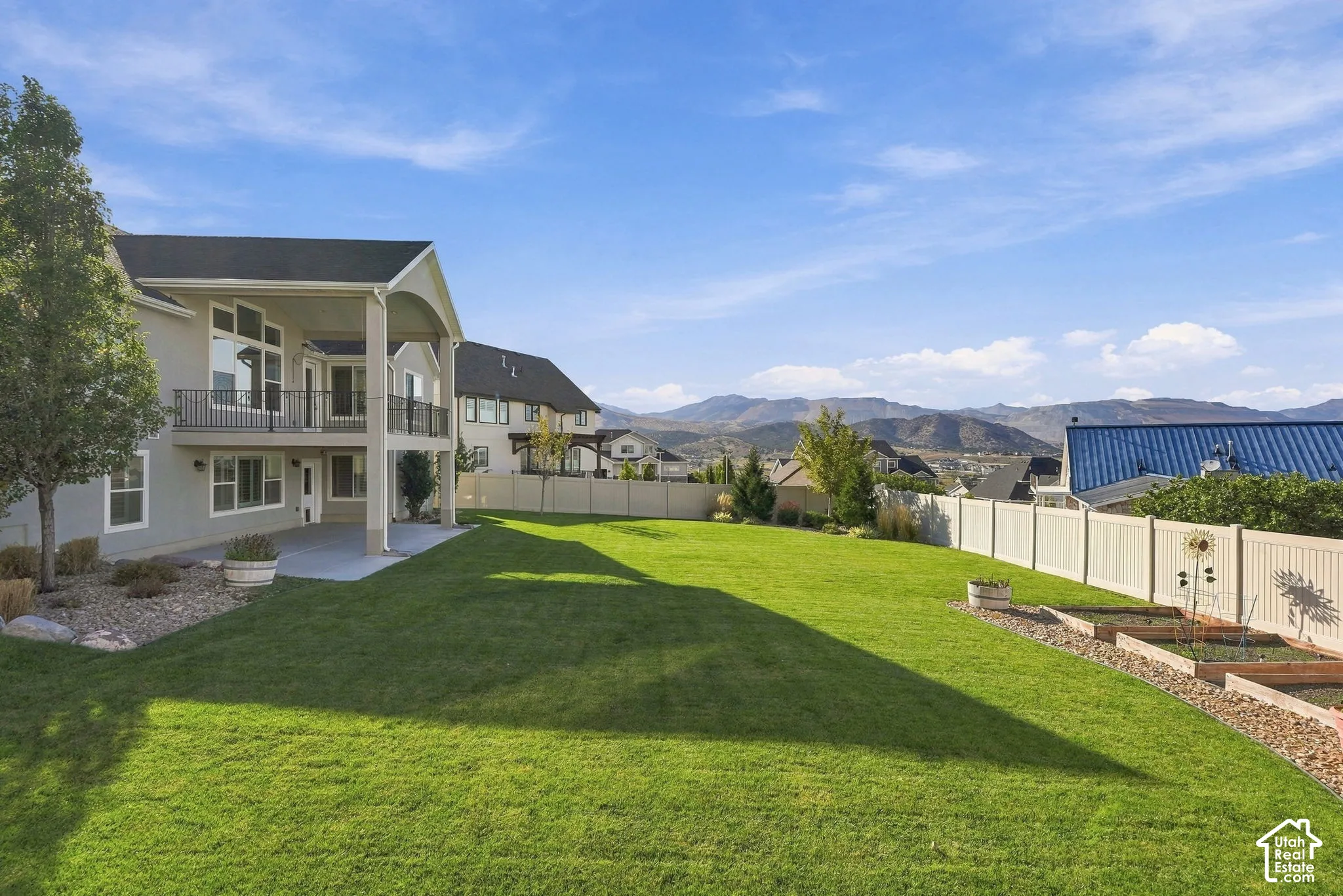 Expansive grassy yard with tiered raised garden beds
