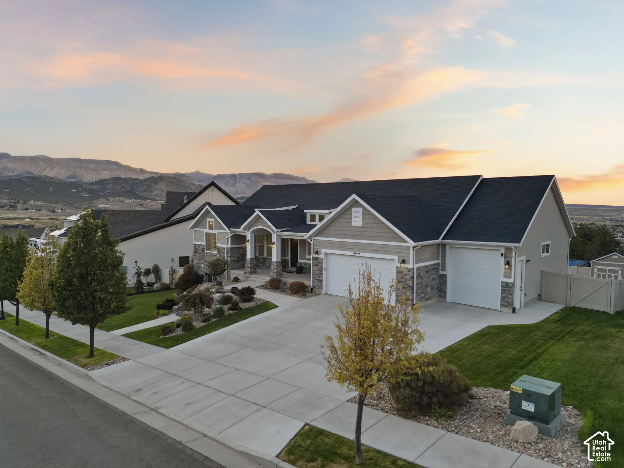 Stone and siding exterior with a dark shingle roof