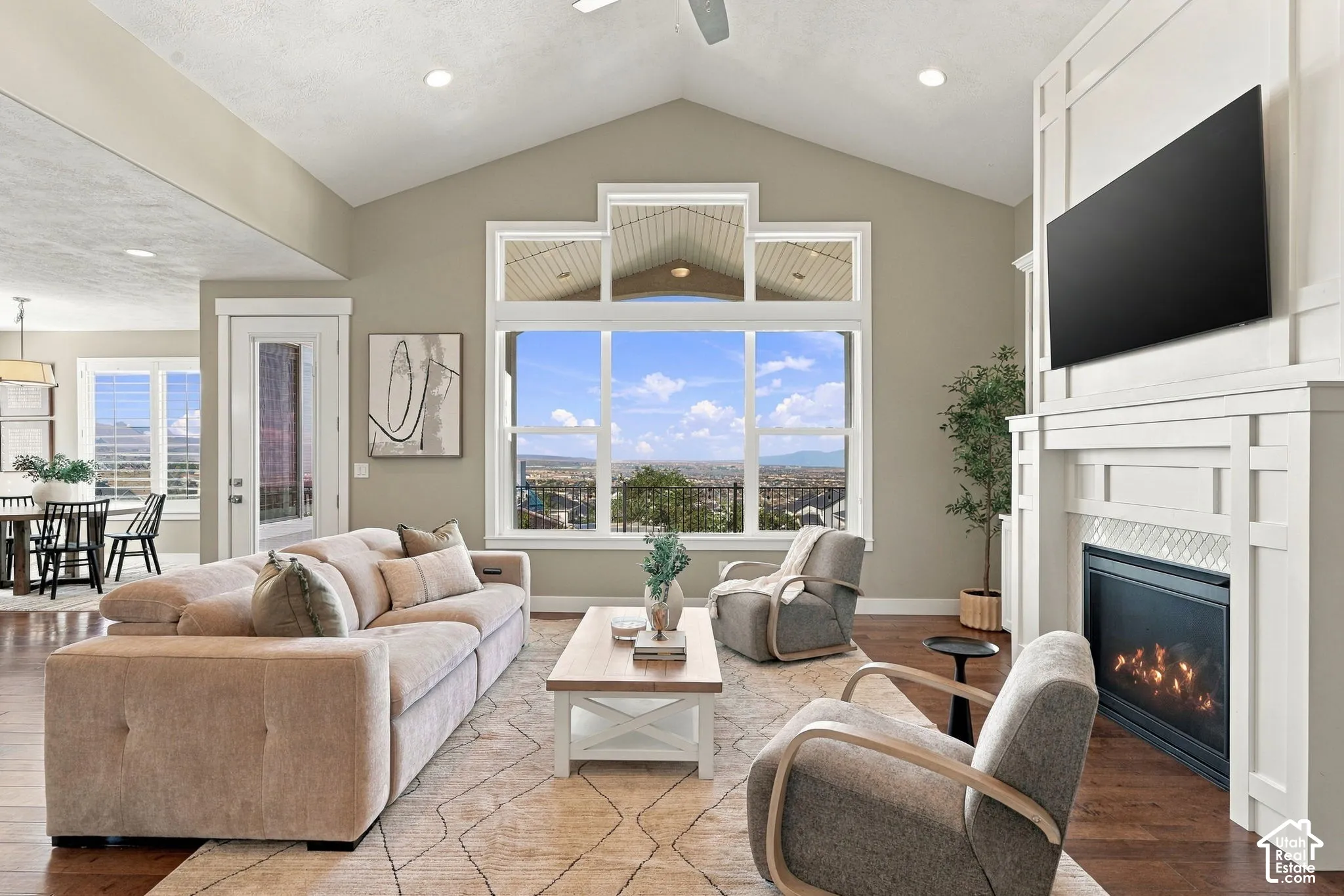 Expansive great room showcasing vaulted ceilings, recessed lighting, and a wall of transom windows framing mountain scenery