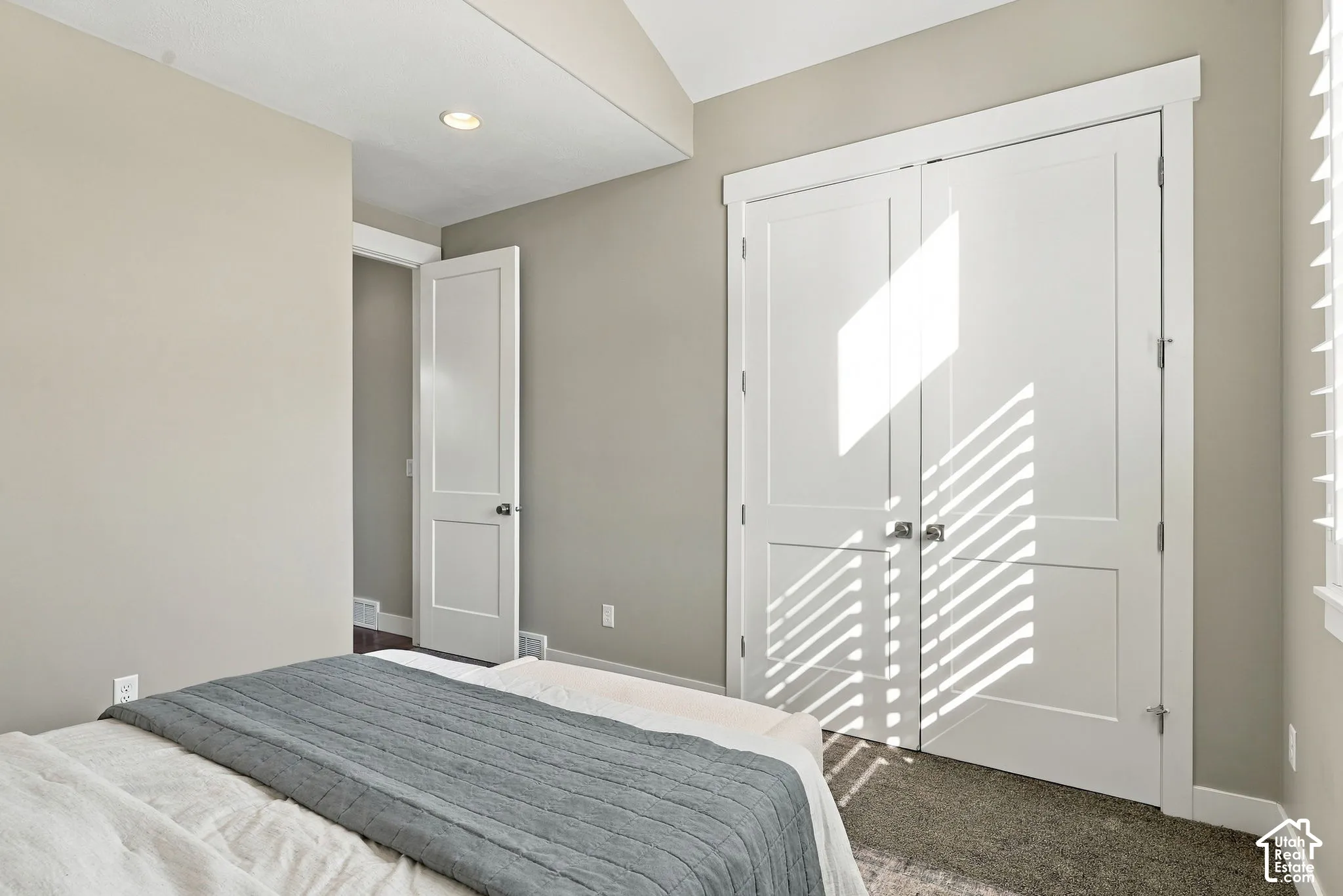 Recessed lighting, neutral wall tones, white interior doors, and textured carpeting