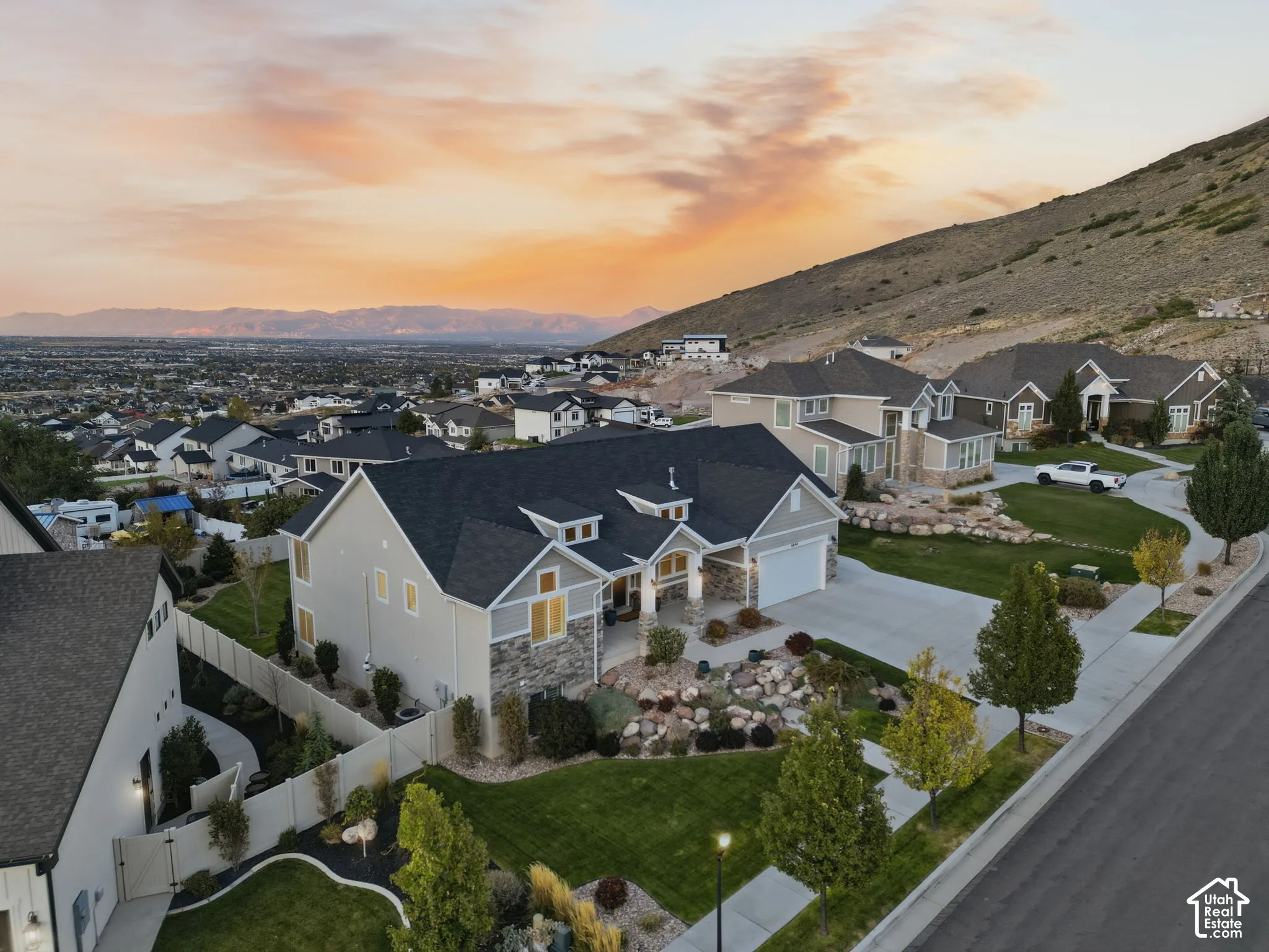 Residences feature mature landscaping, concrete driveways, and stone accents