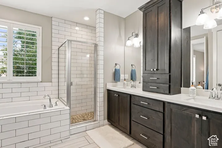 Dual vanity with undermount sinks, white countertops, dark wood-finish cabinetry, and framed mirrors