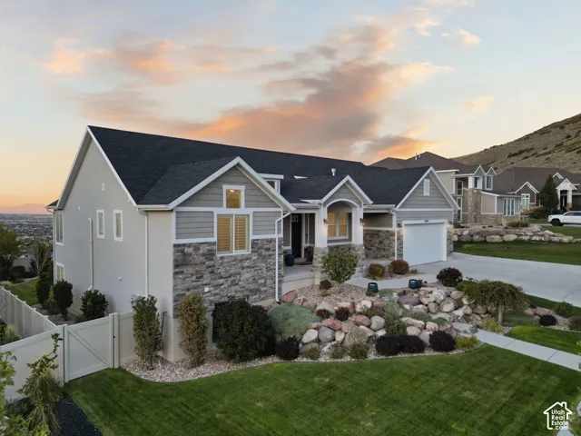 Stone and siding exterior with a dark shingled roof