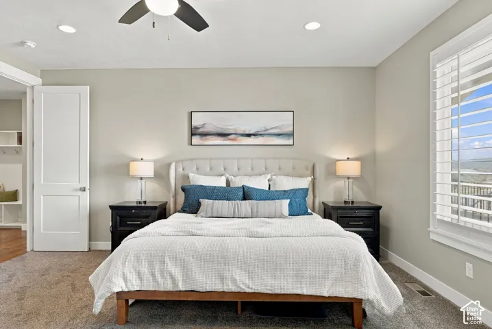 Recessed lighting, ceiling fan, carpet flooring, window with plantation shutters, and a paneled interior door