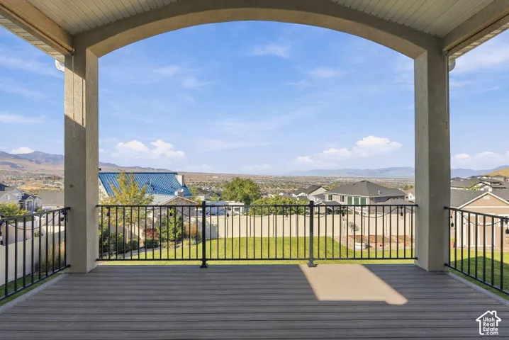 Archway-framed outdoor covered deck with composite decking and black metal railings