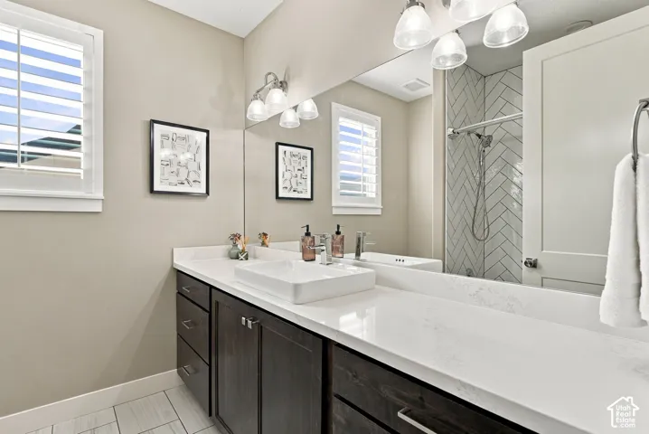 Main floor bathroom two, dark wood-finish vanity with a white rectangular vessel sink, white countertop, and brushed nickel fixtures