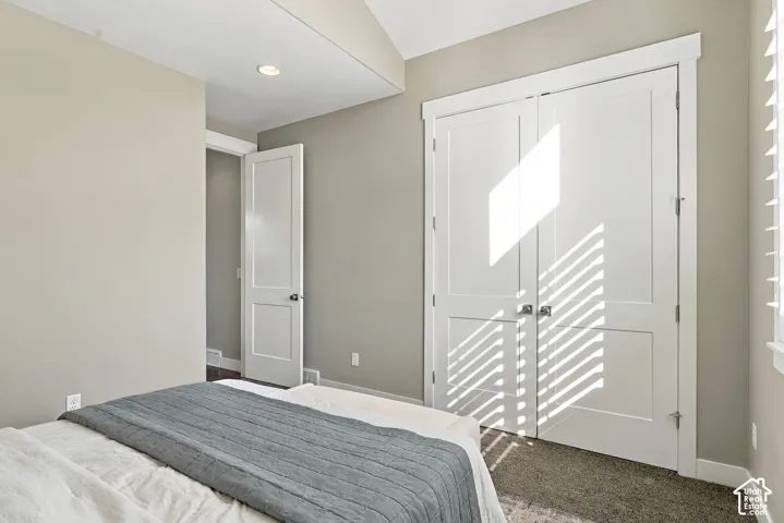 Recessed lighting, neutral wall tones, white interior doors, and textured carpeting