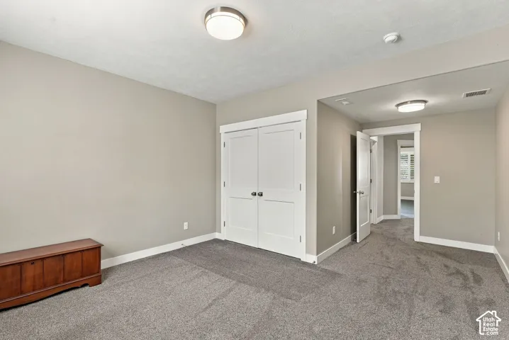 Basement bedroom five, neutral-toned walls complement plush grey carpeting