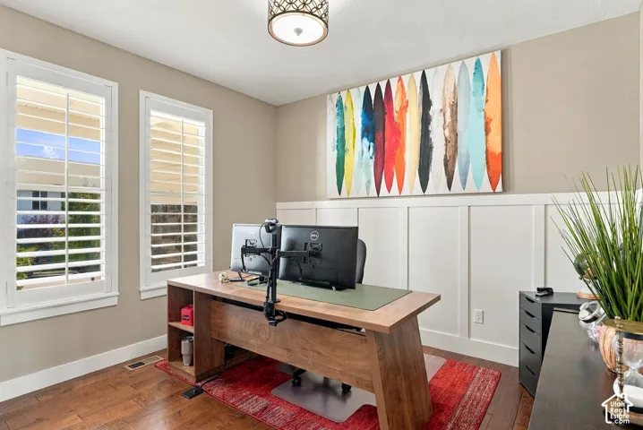 Office on main floor, hardwood flooring, plantation shutters, board and batten wall accent, decorative ceiling light fixture