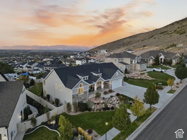 Residences feature mature landscaping, concrete driveways, and stone accents