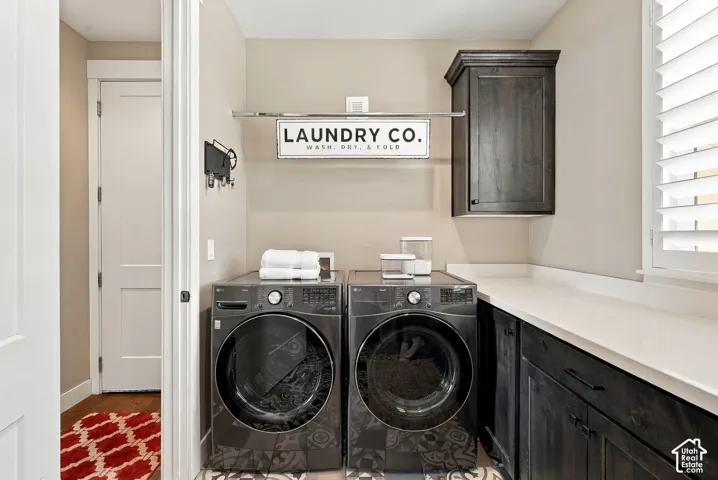 Main floor laundry room featuring a built-in dark wood-finish cabinet, white countertop, and patterned floor tiles