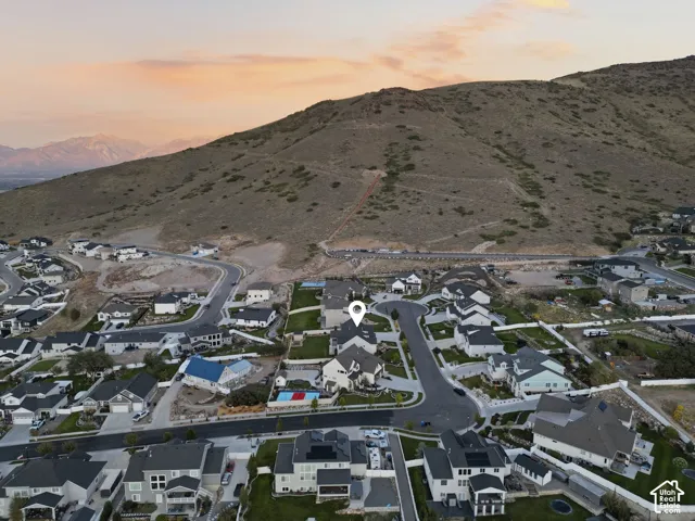 Mountainous terrain backdrop, residential community, paved roadways, manicured landscaping, varied rooflines