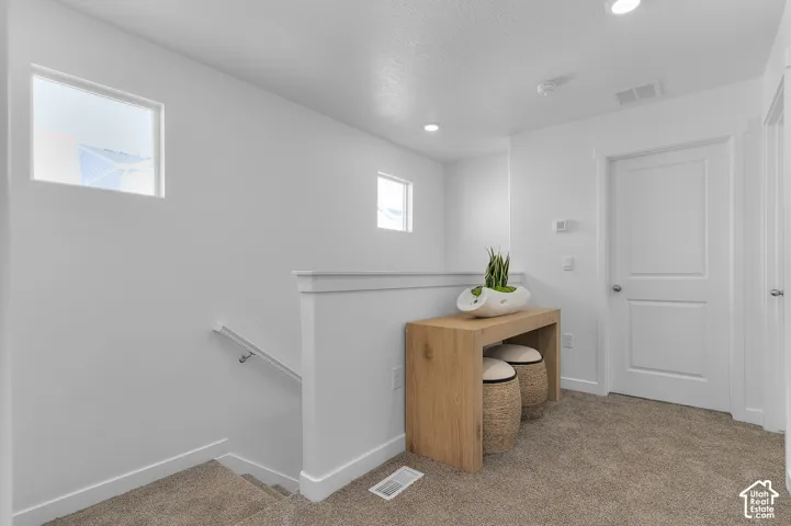 Bright hallway featuring recessed ceiling lighting, dual transom windows, and neutral wall finishes
