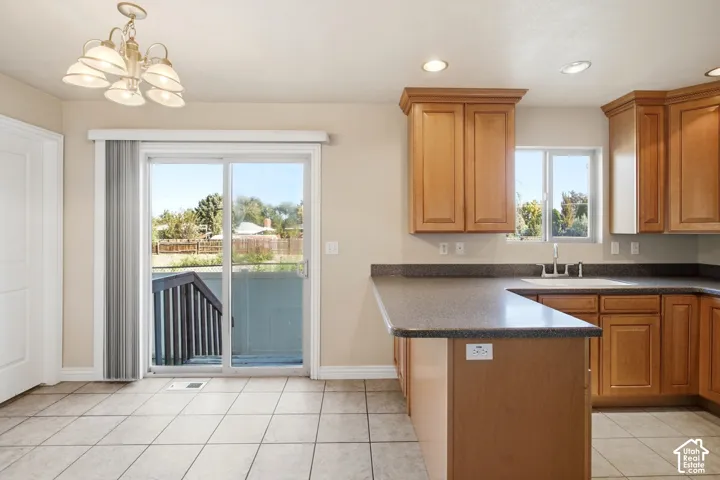 Spacious kitchen featuring wood-finish cabinetry, dark countertops, and a center island with seating