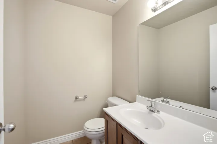 Vanity with wood-finish cabinetry, integrated sink, and chrome-finish faucet