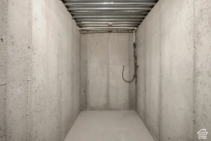 Concrete walls with exposed utilities and a metal ceiling
