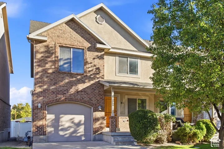 Brick and stucco exterior with an arched garage door
