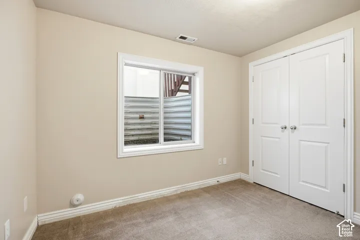 Neutral-toned walls complement the carpeted flooring