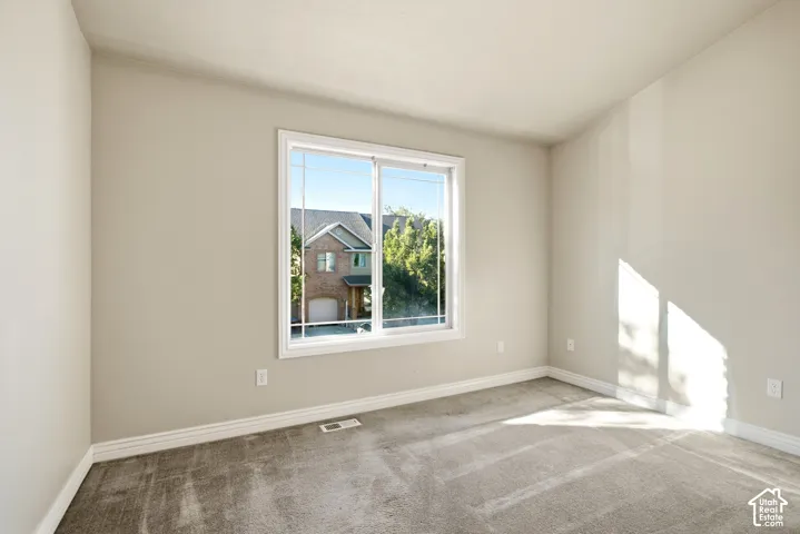 Soft gray wall paint with white trim, gray carpeting, and a large window