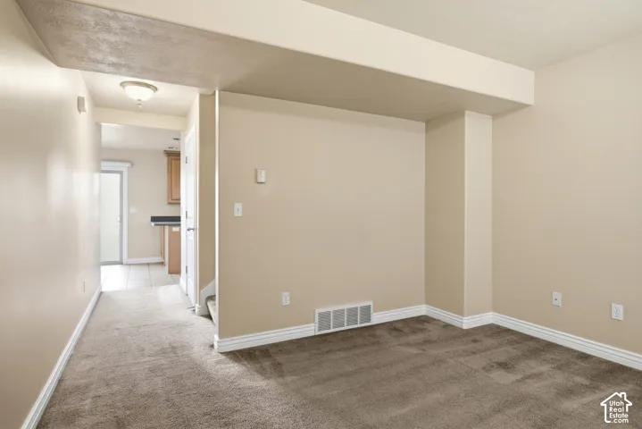 Carpeted flooring, neutral wall tones, and white trim throughout