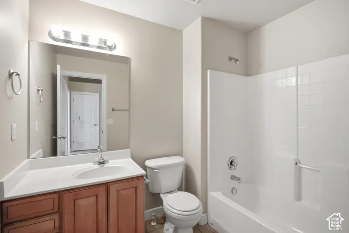 Spa-inspired bathroom featuring warm wood-finish cabinetry with an undermount sink, white subway tile surround, and an integrated tub-shower combination with chrome fixtures and grab bars
