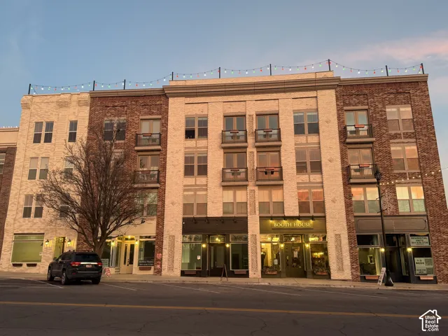 Mixed-use building featuring brick and stone facades, balconies, and ground-floor retail spaces