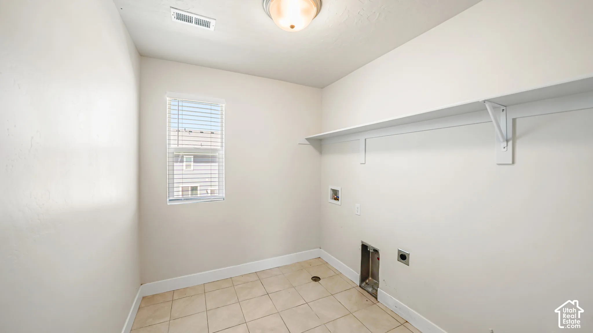 Ceramic tile flooring, built-in shelving, a window with blinds, and white walls