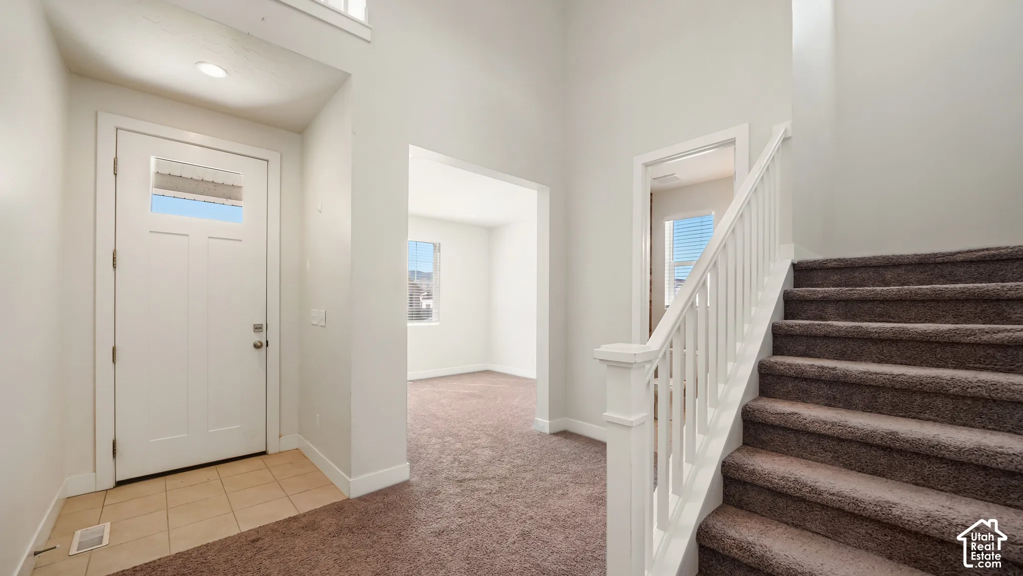Entryway featuring a white paneled door with glass inserts, recessed lighting, and tile flooring