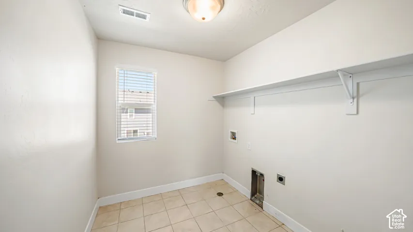 Ceramic tile flooring, built-in shelving, a window with blinds, and white walls