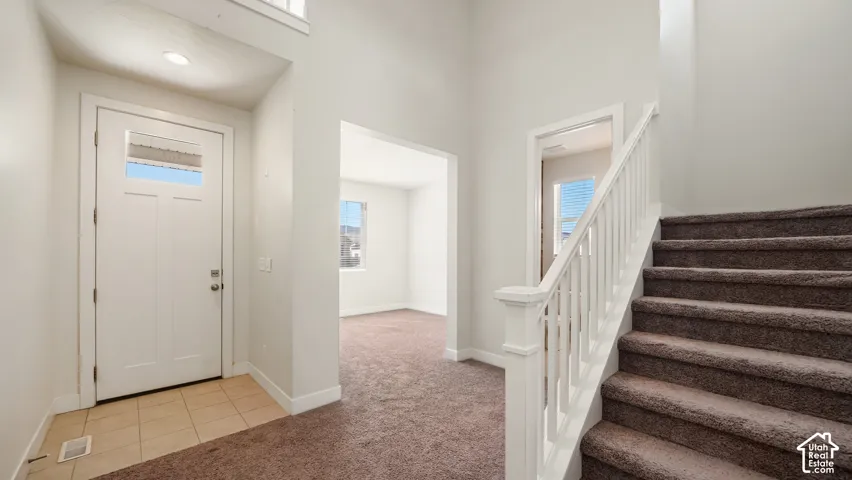 Entryway featuring a white paneled door with glass inserts, recessed lighting, and tile flooring