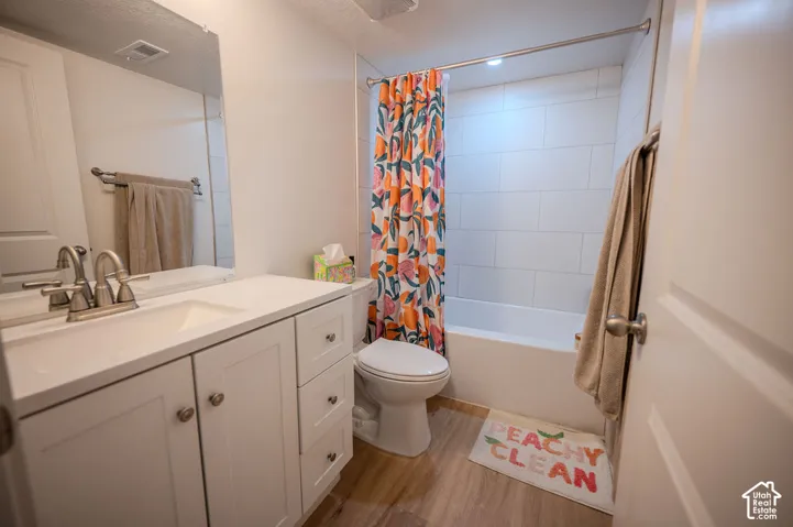 White vanity with brushed nickel hardware, integrated sink, and a large wall-mounted mirror