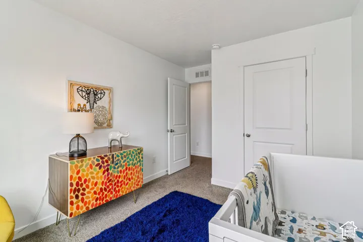 White walls with carpet flooring, a white interior door, and white trim