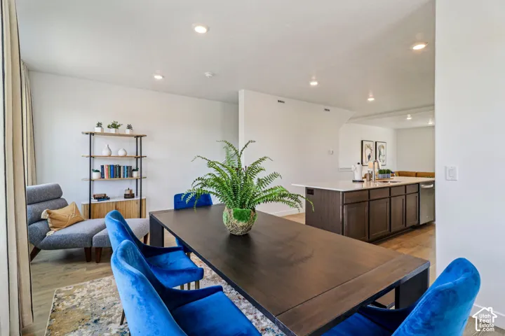 Recessed lighting, wood-finish flooring, and a kitchen island with built-in cabinetry and a stainless steel dishwasher