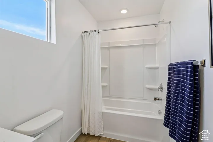 White bathtub and shower combination with chrome fixtures